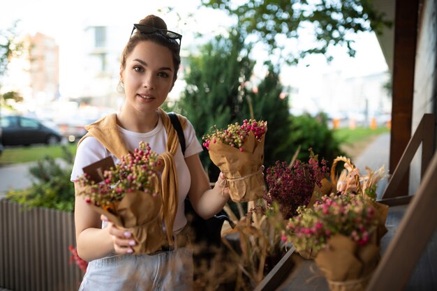 Attractive young woman in casual look buys flowers in the store