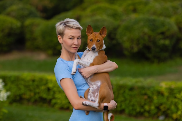 Attractive young woman holding a dog in her arms