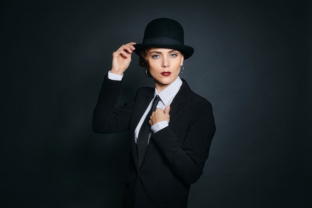 Attractive young woman in a man's suit and a fedora. retro style photo shoot