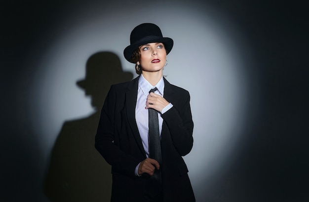 Attractive young woman in a man's suit and a fedora. retro style photo shoot