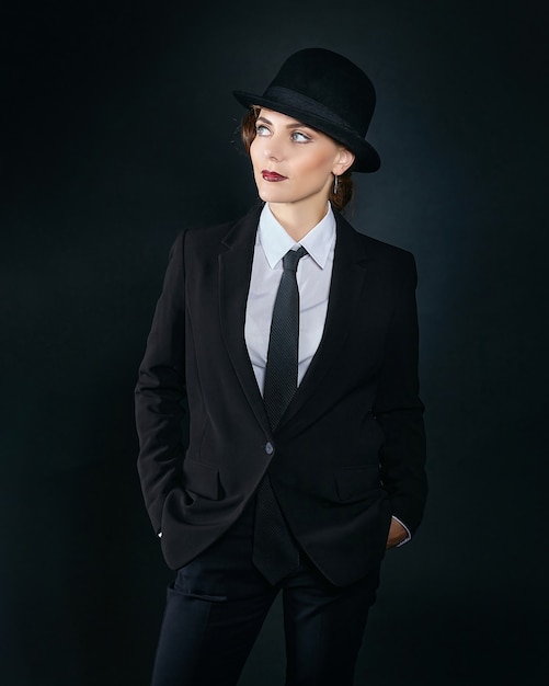 Attractive young woman in a man's suit and a fedora. retro style photo shoot