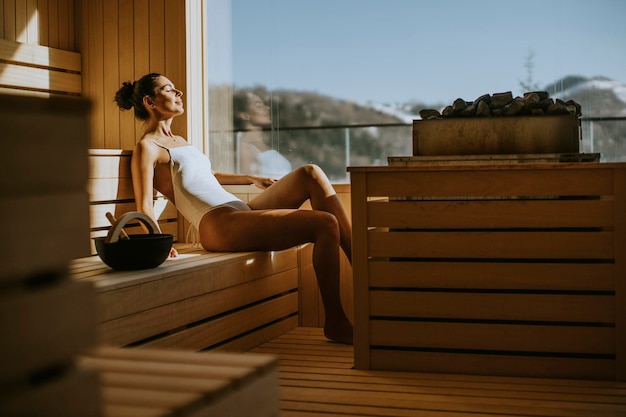 Attractive young woman relaxing in the sauna