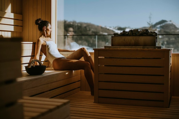 Attractive young woman relaxing in the sauna