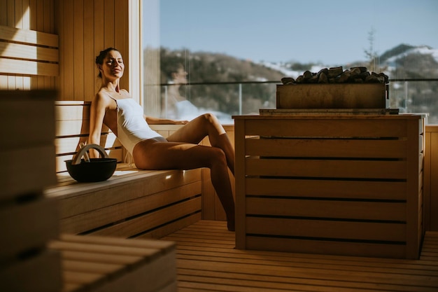 Attractive young woman relaxing in the sauna