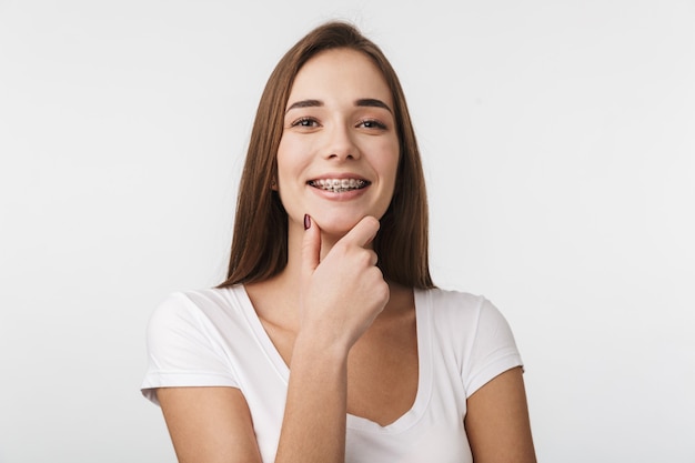 Attractive young woman standing isolated over white wall, laughing