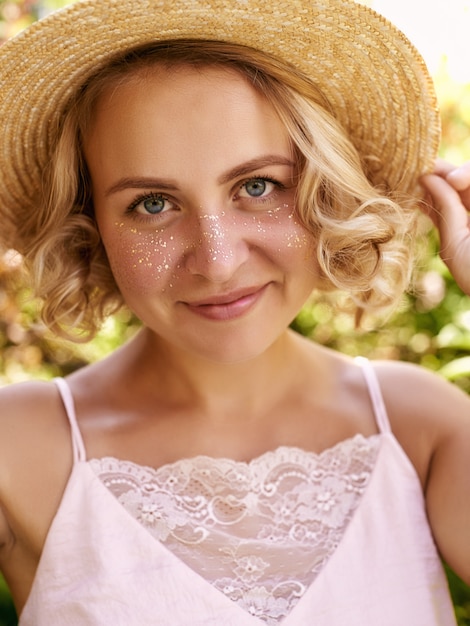 Attractive young woman with golden freckles enjoying her time outside in park with sunset in background.