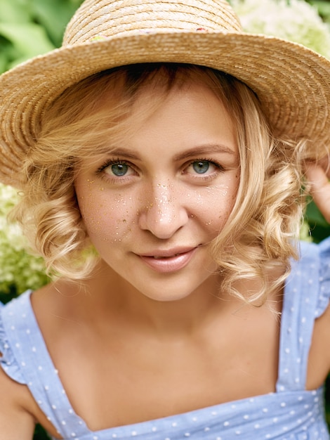 Attractive young woman with golden freckles enjoying her time outside in park with sunset in background.