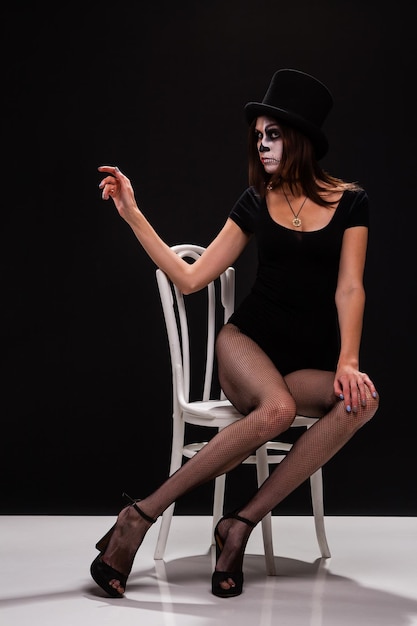 Attractive young woman with gothic vampire makeup on helloween party over black backgroundhalloween make up face