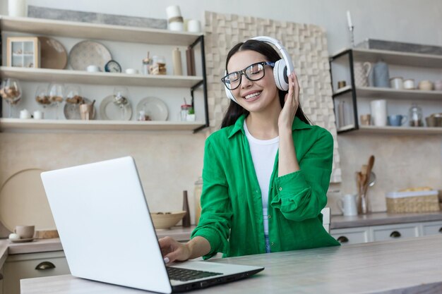 Attractive young woman working with laptop and listening music at home