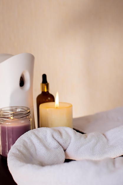 attributes for massage are on the table massage oil cream candles towel aroma diffuser