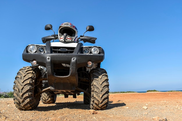 ATV offroad on mountain and sky background