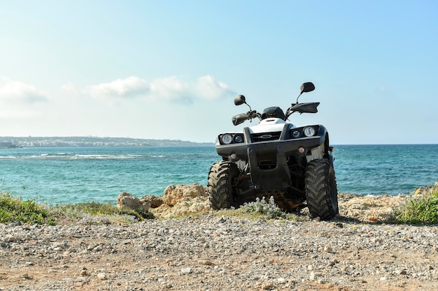 ATV offroad on mountain and sky background