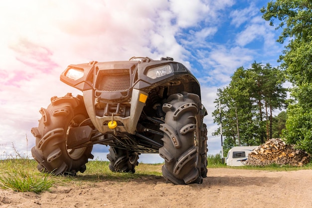 ATV on the sandy shore of the lake on the background of the camp