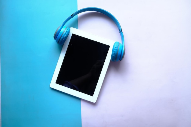 Audio book concept Headphones and digital tablet on table