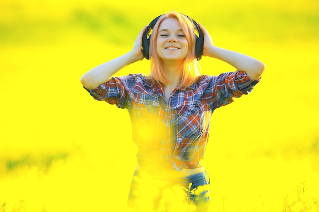 audio headphones summertime girl music in a field of flowers, young female spring