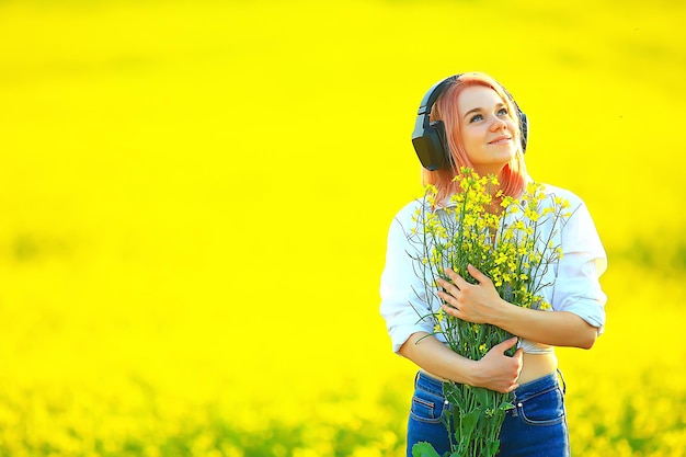 audio headphones summertime girl music in a field of flowers, young female spring