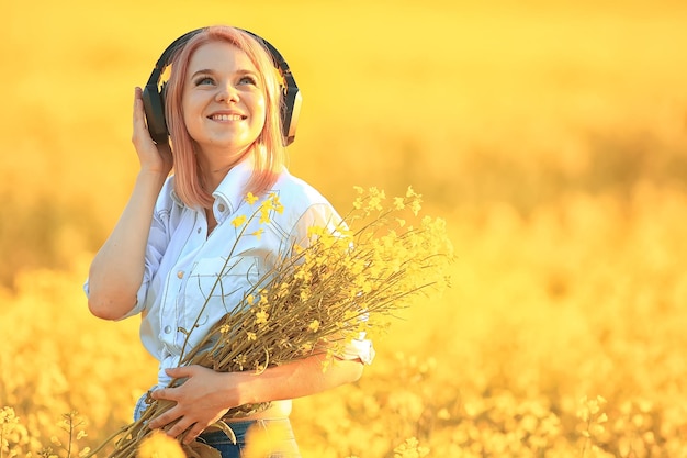 audio headphones summertime girl music in a field of flowers, young female spring