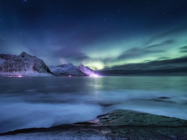 Aurora borealis on Lofoten islands Norway Green northern lights above mountains Night winter landscape with aurora Natural background in the Norway