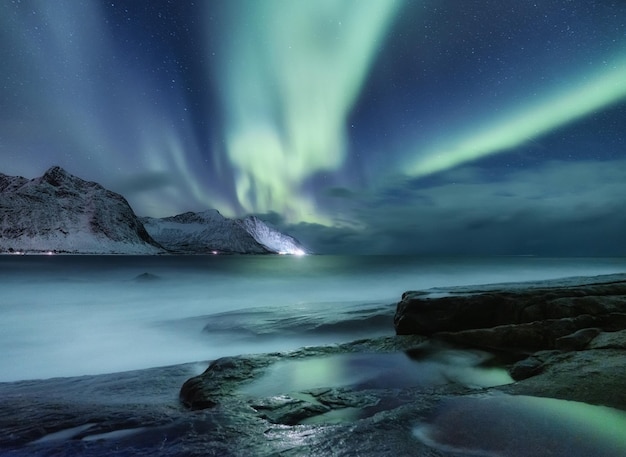 Aurora borealis on Lofoten islands Norway Green northern lights above mountains Night winter landscape with aurora Natural background in the Norway