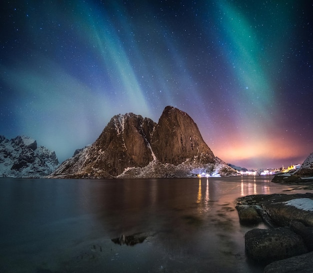 Aurora borealis on mountain in fishing village at Hamnoy