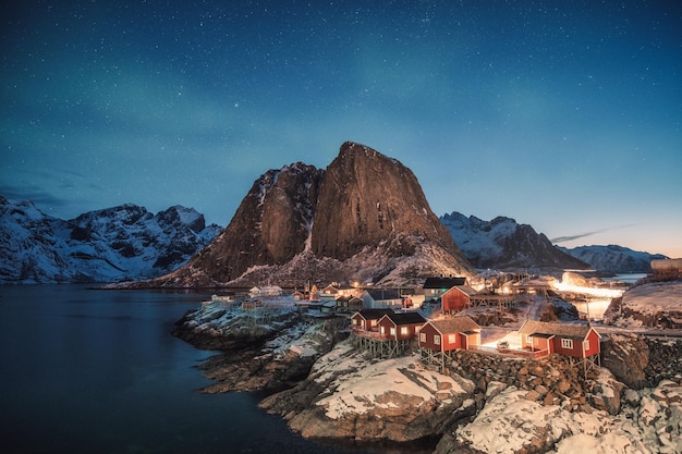 Aurora borealis over mountain with fishing village at Hamnoy