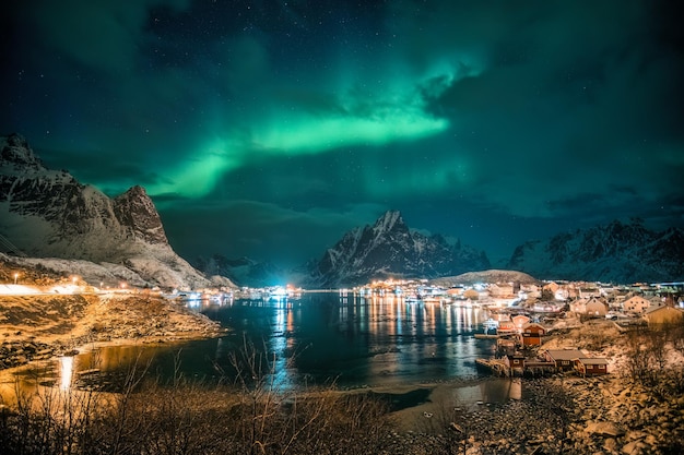 Aurora borealis over Reine town on coastline at Lofoten Islands