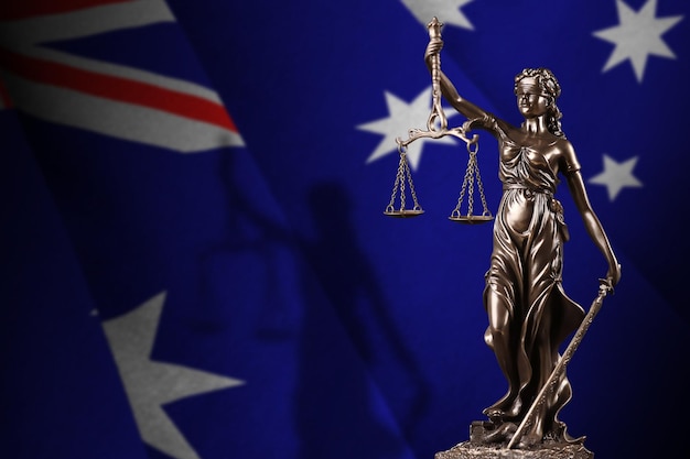 Australia flag with statue of lady justice and judicial scales in dark room Concept of judgement and punishment