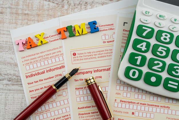 Australian annual corporate tax form with pen and calculator on desk