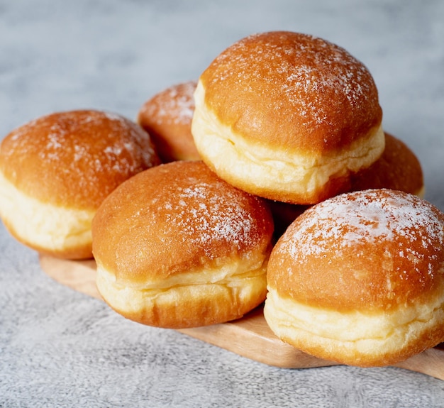 Austrian and german donuts or krapfen Faschingskrapfen berliner with cream on grey background