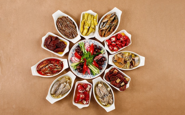 Authentic greek maze platter on white bowls in wooden background top view. Mediterranean dish photography for online delivery menu or party food options concept.