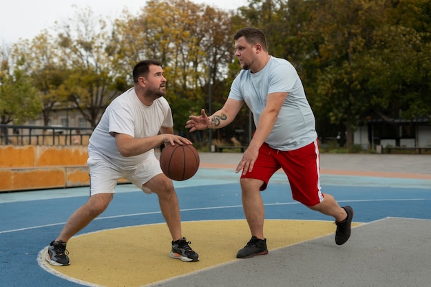 Authentic scenes of plus-size males playing basketball