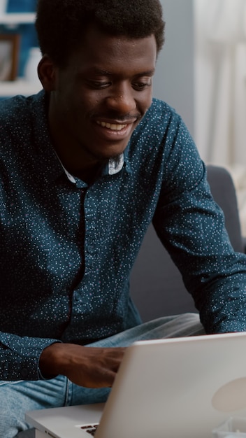 Authentic smiling young guy working from home