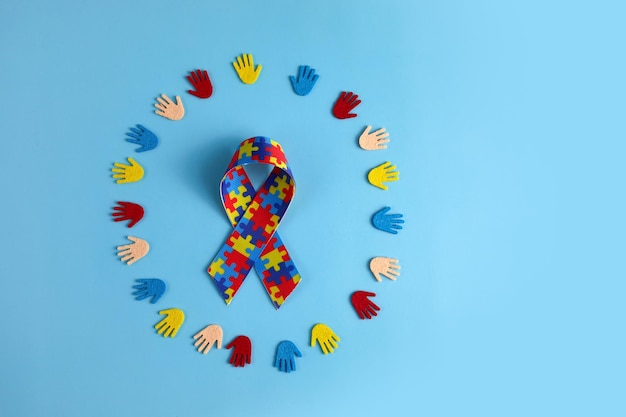 Autism awareness concept with colorful hands on blue background top view