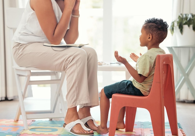 Autism education and mental health by therapist and child learning different hand sign to express feelings in living room Teaching speech and child development with boy and woman lesson on emotion