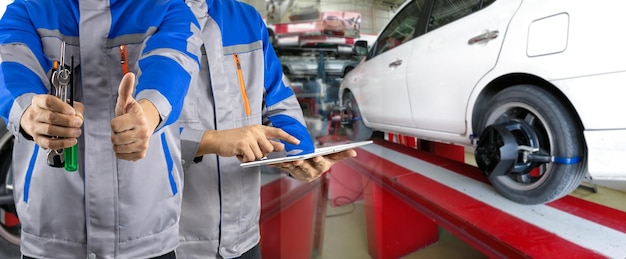 Auto mechanic analyzes and aligns automobile wheels The car checks the wheel sensors on for wheels alignment