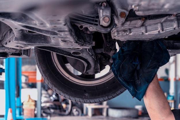 Auto mechanic changing oil machine.    The man is changing the motor oil.Change engine oil.Replacement of automobile oil.Check the auto maintenance.transportation repair service center