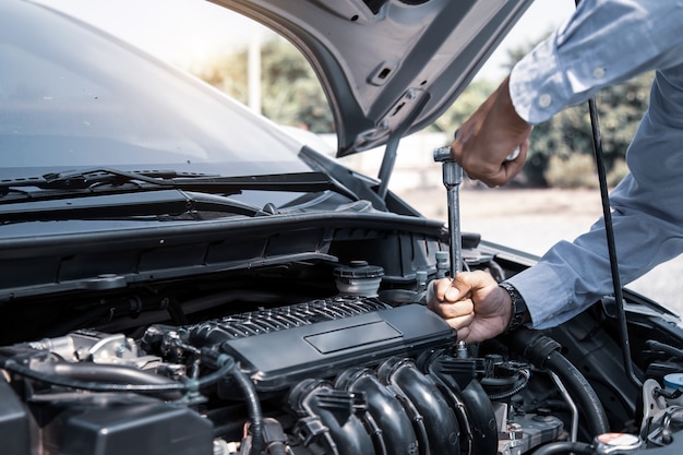 Auto mechanic hands using wrench to repair a car engine