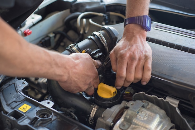 Auto mechanic repairing car. Selective focus.