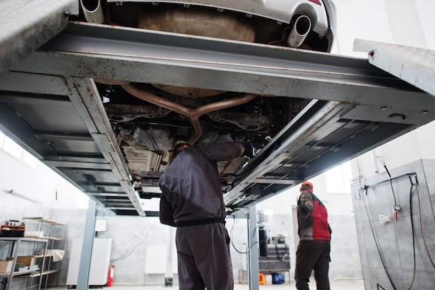 Auto mechanic sets american SUV car for diagnostics and configuration camber check in workshop of service station