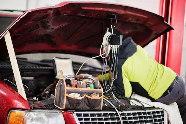 Auto mechanic sets american SUV car for diagnostics and configuration in workshop service station