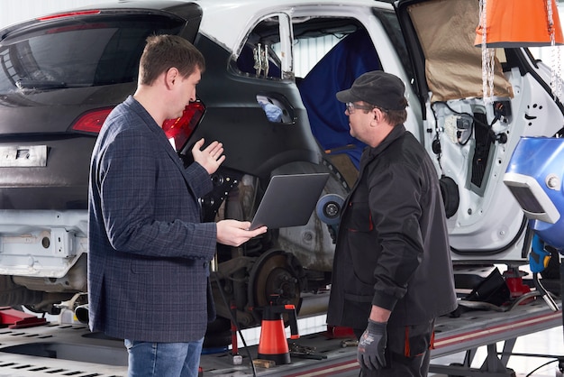 Auto mechanic and technician working in repair shop