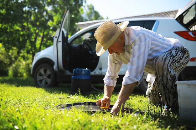 Auto trim cleaning Washing manual car A grayhaired man cleans his vehicle