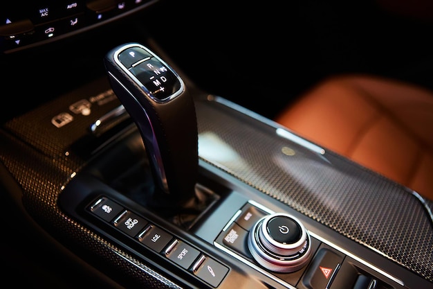 Automatic gear stick of a modern car, multimedia and navigation control buttons. Car interior details. Transmission shift. Shallow dof.