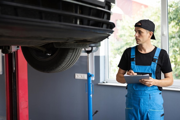 Automobile service car mechanic car mechanic at a repair shop taking notes on his tablet car service