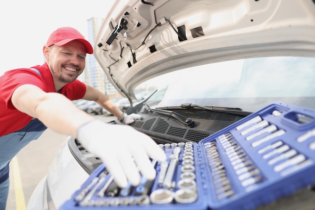 Automotive technician smiling and take instrument from open kit