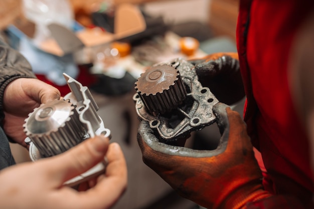 Automotive water pump of the engine cooling system in the hands of an auto mechanic replacement 