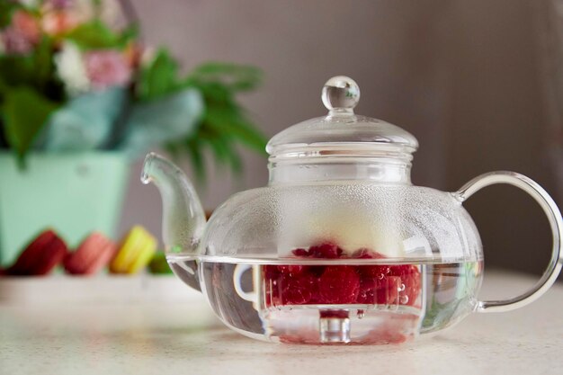 Autumn aesthetic vibes natural raspberry ransparent teapot close up macaroons and bouquet of flowers