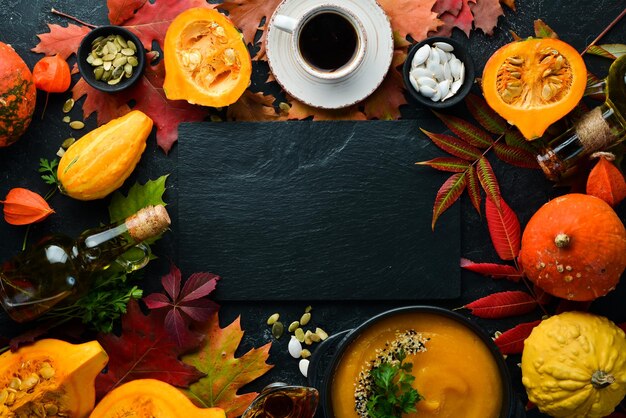 Autumn background with coffee pumpkin autumn leaves and seeds flat lay On a black stone background Top view Free space for your text