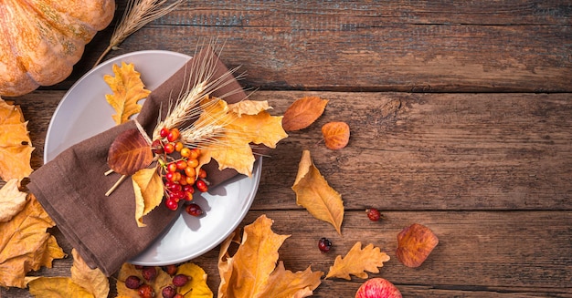 Autumn background with cutlery and autumn leaves on a wooden background