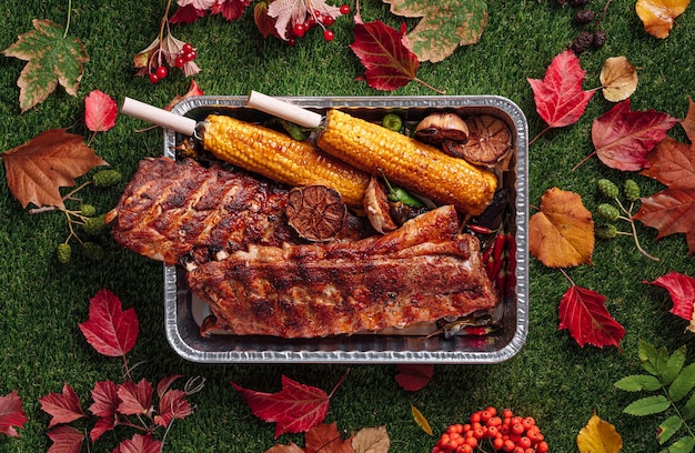 Autumn bbq grilled pork ribs corn and grilled peppers baked garlic autumn grill party concept Thanksgiving Day autumn harvest